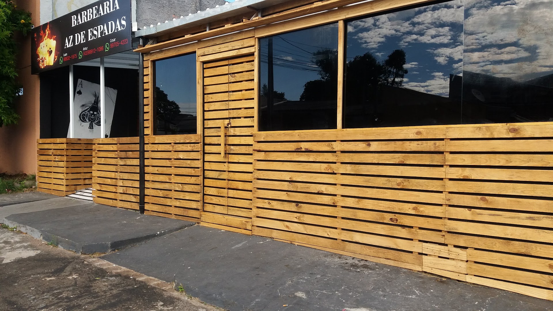 Fachada de madeira com letreiro em chamas da Barbearia Az De Espadas, no Capão Raso